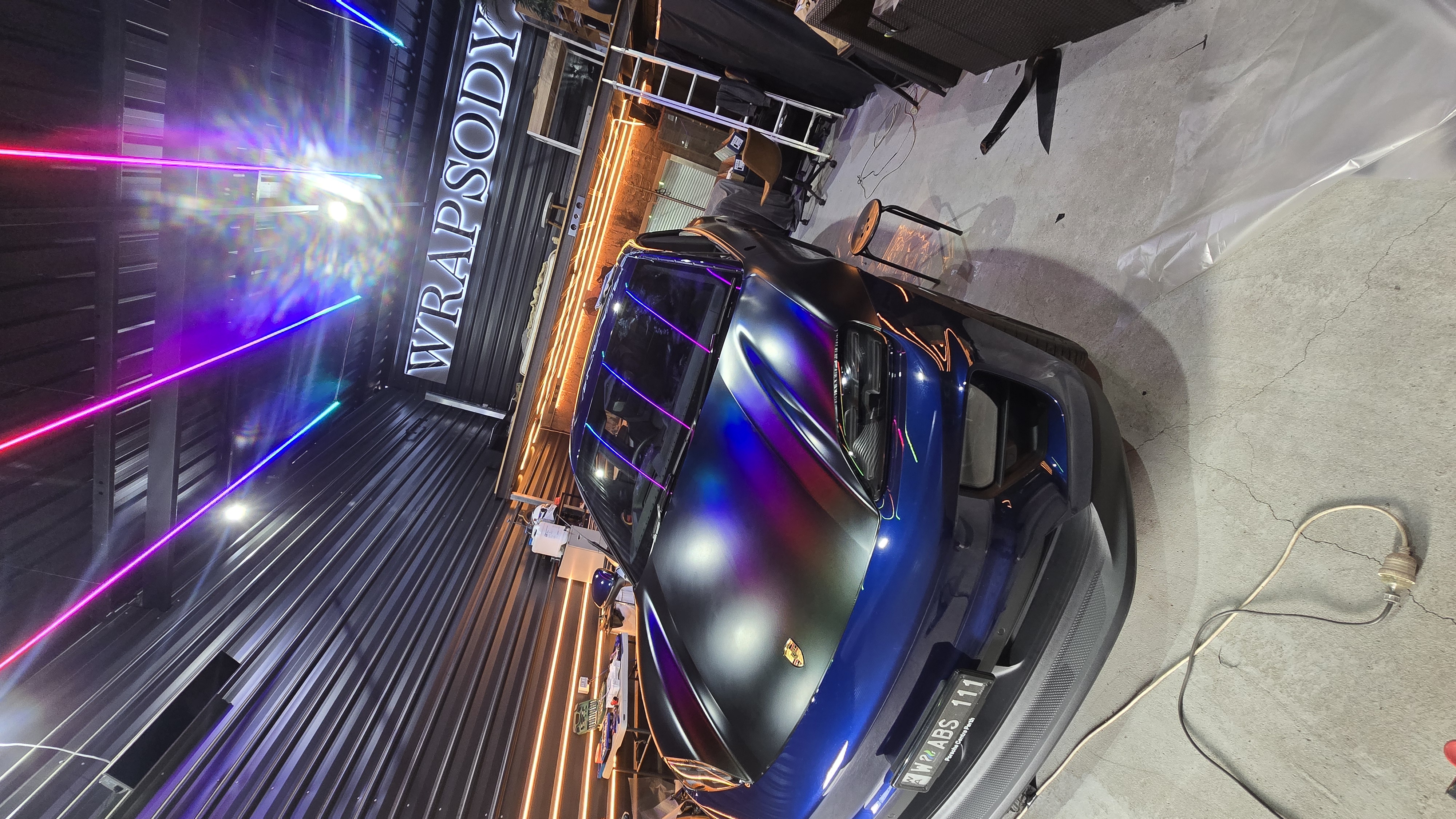 Chameleon wrap under studio neon lights with Wrapsody sign