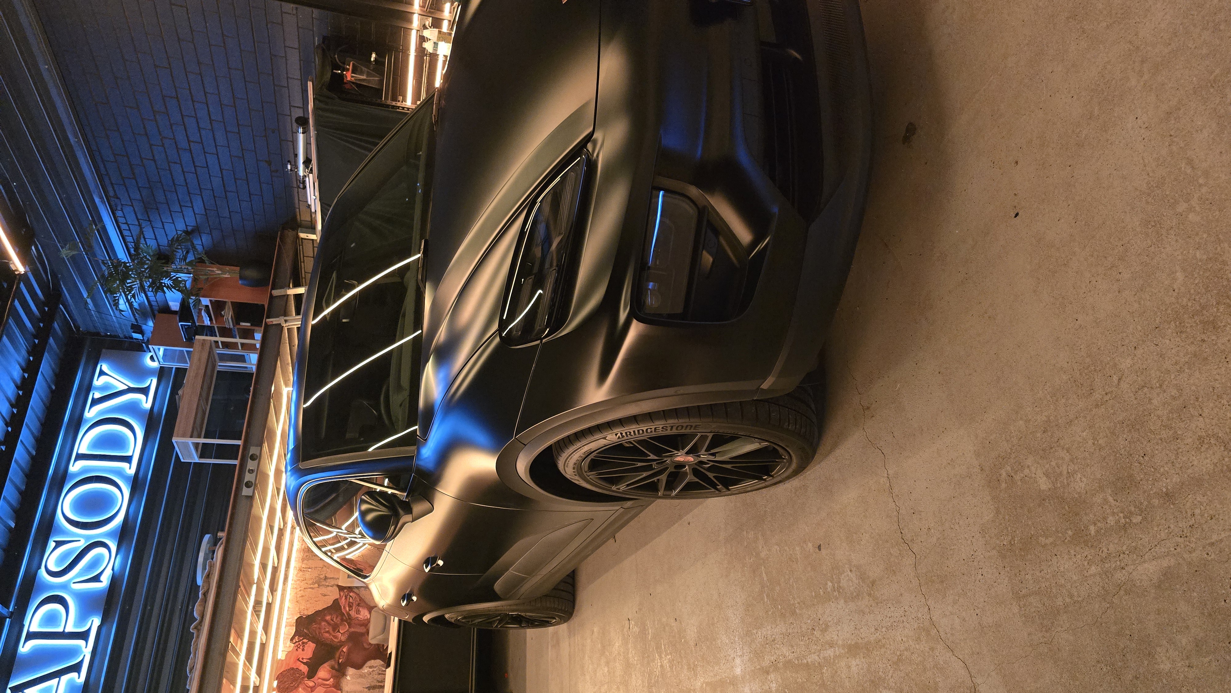 Wrapsody studio with neon sign and car
